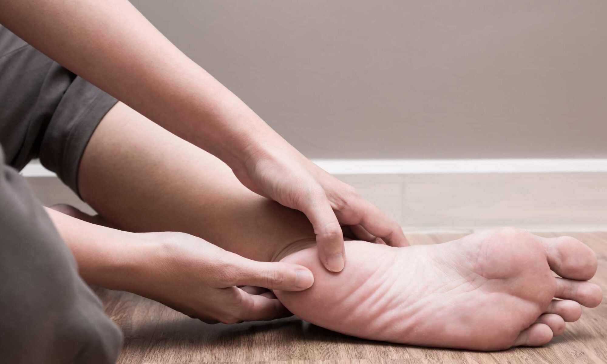 Mujer se toca el pie dolorido por fascitis plantar